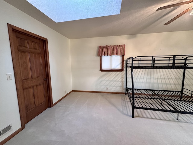 5200 Pine Grove Dr, Spruce, MI 48762 - unfurnished bedroom featuring a skylight, carpet, and a textured ceiling