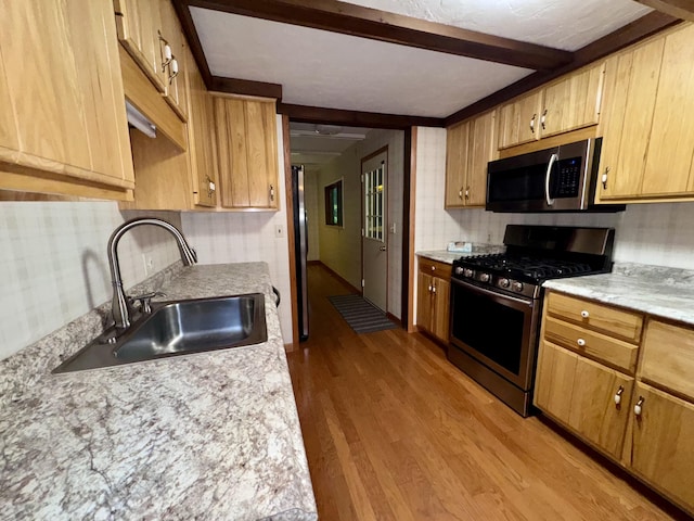 5200 Pine Grove Dr, Spruce, MI 48762 - kitchen with stainless steel appliances, wood finished floors, light countertops, and beam ceiling