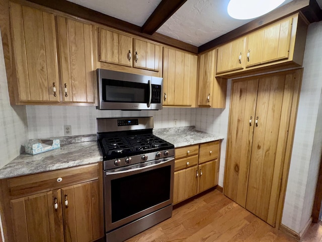 5200 Pine Grove Dr, Spruce, MI 48762 - kitchen with appliances with stainless steel finishes, light wood-style flooring, beamed ceiling, and light stone counters