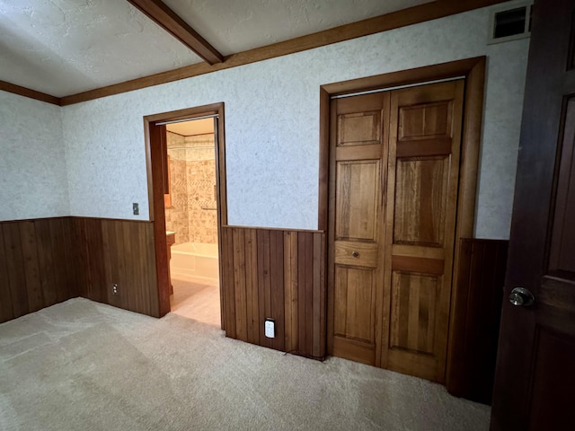5200 Pine Grove Dr, Spruce, MI 48762 - unfurnished bedroom with wainscoting, carpet flooring, connected bathroom, a textured ceiling, and wooden walls