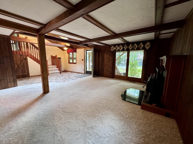 5200 Pine Grove Dr, Spruce, MI 48762 - unfurnished living room featuring stairway, carpet, wood walls, and beamed ceiling