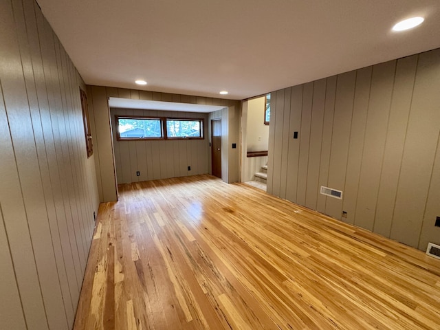 5200 Pine Grove Dr, Spruce, MI 48762 - spare room featuring light wood finished floors, stairway, and wooden walls