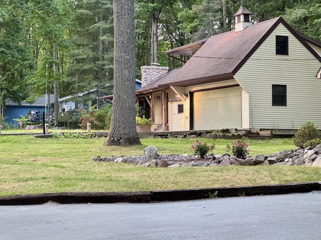 5200 Pine Grove Dr, Spruce, MI 48762 - view of front facade featuring a chimney, a front yard, an attached garage, and a shingled roof