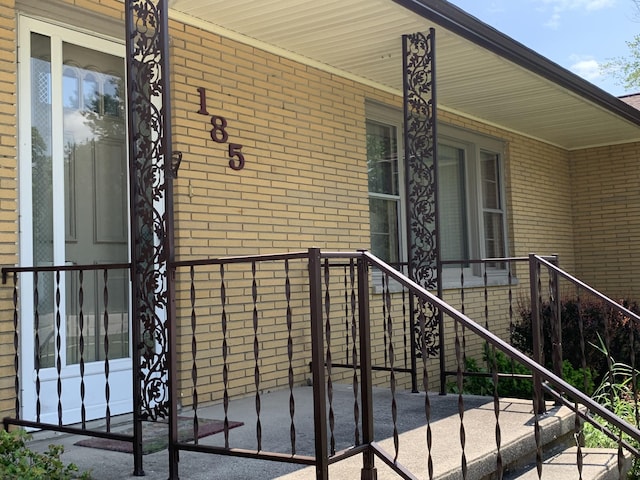 185 S June St, Alpena, MI 49707 - view of exterior entry with brick siding and covered porch
