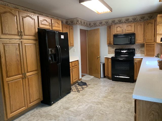185 S June St, Alpena, MI 49707 - kitchen with black appliances, light countertops, brown cabinetry, and decorative backsplash