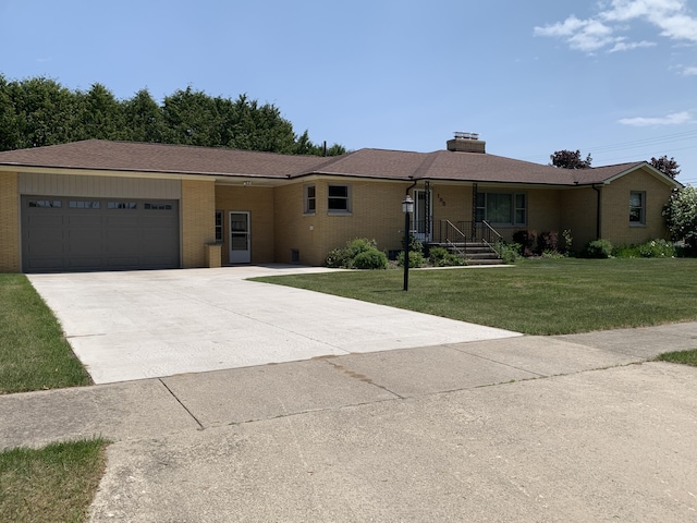 185 S June St, Alpena, MI 49707 - single story home featuring a garage, concrete driveway, brick siding, a front lawn, and a chimney