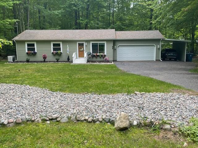 95 Caduca Ln, Roscommon, MI 48653 - single story home featuring asphalt driveway, entry steps, a front lawn, an attached garage, and a carport