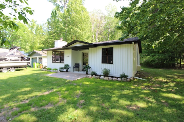 211 Daytona Rd, Roscommon, MI 48653 - view of front of house featuring a chimney, a patio, and a front yard