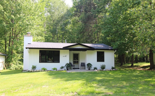 211 Daytona Rd, Roscommon, MI 48653 - view of front of property featuring a chimney, a front yard, and roof with shingles