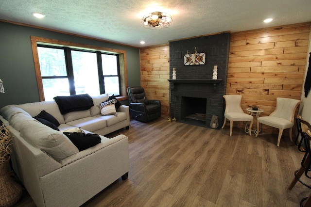 211 Daytona Rd, Roscommon, MI 48653 - living area featuring a textured ceiling, wood walls, wood finished floors, a fireplace, and recessed lighting
