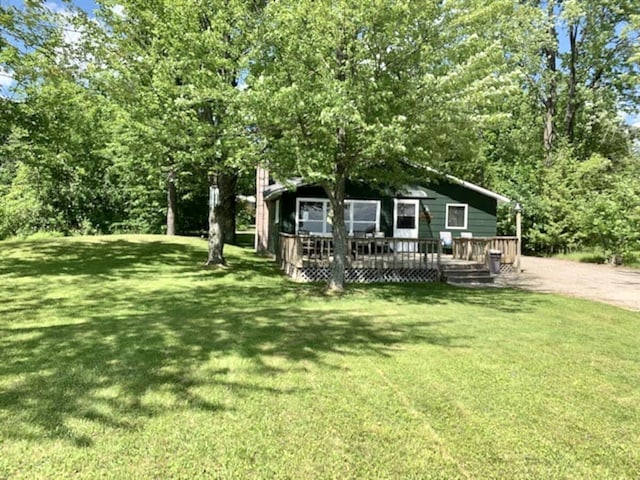 14781 Shubert Hwy, Posen, MI 49776 - view of front of home featuring a wooden deck and a front lawn