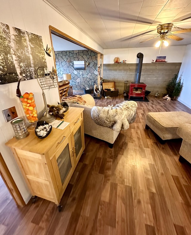 14781 Shubert Hwy, Posen, MI 49776 - living room featuring a wood stove, dark wood finished floors, and a ceiling fan