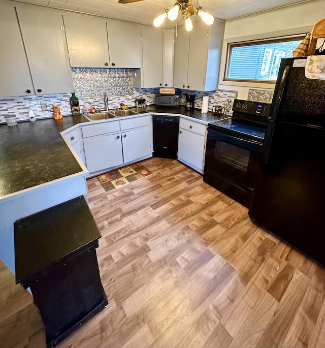 14781 Shubert Hwy, Posen, MI 49776 - kitchen featuring black appliances, dark countertops, white cabinetry, and tasteful backsplash