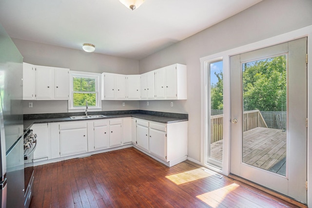 1014 Court St, Cheboygan, MI 49721 - kitchen featuring dark wood finished floors, dark countertops, and white cabinets