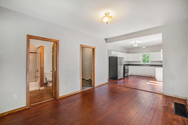 1014 Court St, Cheboygan, MI 49721 - unfurnished living room with a sink and dark wood-style flooring