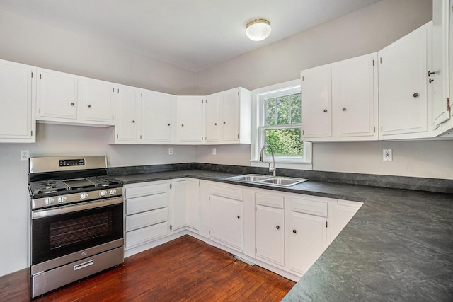 1014 Court St, Cheboygan, MI 49721 - kitchen with stainless steel gas stove, dark countertops, and white cabinets