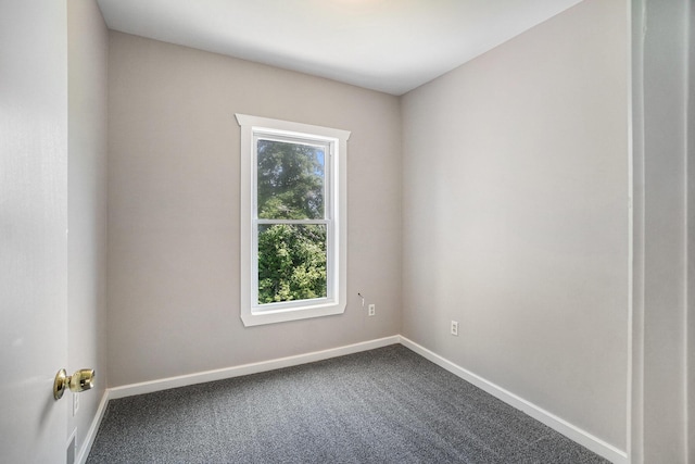1014 Court St, Cheboygan, MI 49721 - spare room with baseboards and dark colored carpet