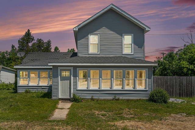 1014 Court St, Cheboygan, MI 49721 - back of property at dusk featuring a shingled roof
