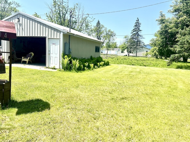 1604 Harrison Ave, Cheboygan, MI 49721 - view of green lawn featuring a detached garage and an outbuilding