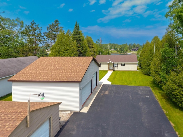 1817 Lindburgh Ln, Cheboygan, MI 49721 - view of front of home featuring a front yard, an outdoor structure, and roof with shingles
