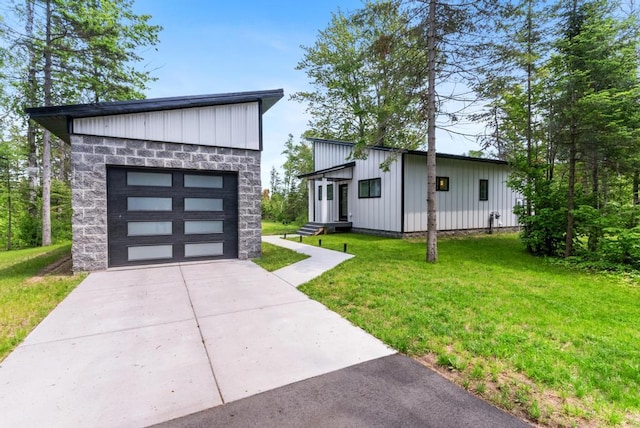 2960 W US-23 Hwy, Cheboygan, MI 49721 - view of front of property featuring board and batten siding, driveway, a front yard, and stone siding