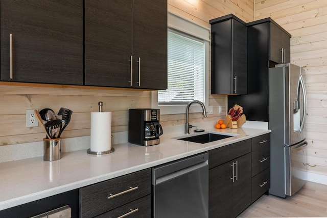 2960 W US-23 Hwy, Cheboygan, MI 49721 - kitchen featuring appliances with stainless steel finishes, wooden walls, light countertops, and light wood-style flooring