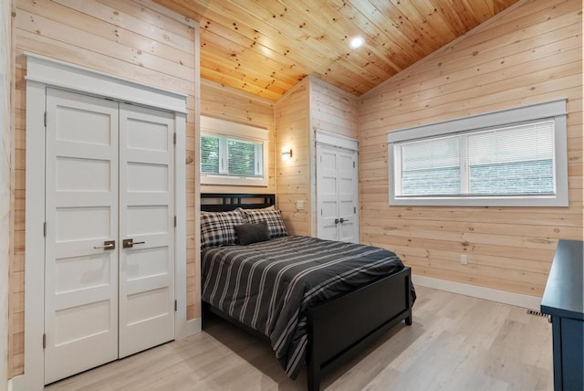 2960 W US-23 Hwy, Cheboygan, MI 49721 - bedroom featuring vaulted ceiling, light wood-type flooring, wooden ceiling, wood walls, and two closets