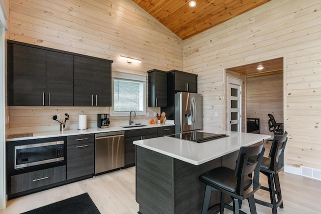 2960 W US-23 Hwy, Cheboygan, MI 49721 - kitchen with appliances with stainless steel finishes, wood ceiling, dark cabinetry, a kitchen bar, and light wood-style floors