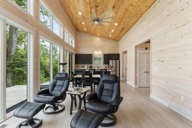2960 W US-23 Hwy, Cheboygan, MI 49721 - living area with high vaulted ceiling, wooden walls, wooden ceiling, light wood-style flooring, and a ceiling fan