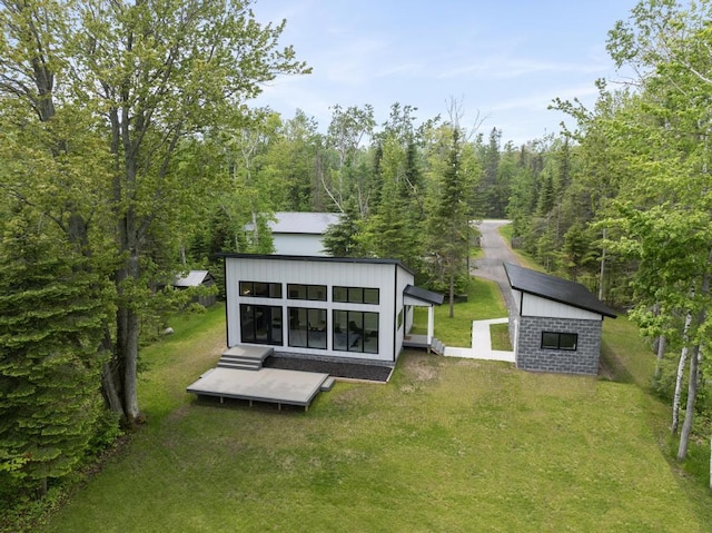 2960 W US-23 Hwy, Cheboygan, MI 49721 - rear view of property featuring a lawn, an outdoor structure, and a view of trees