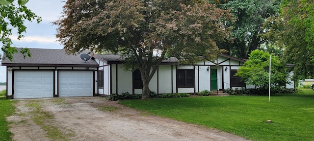 3211 S Partridge Point Rd, Alpena, MI 49707 - view of front of house featuring dirt driveway, a front lawn, an attached garage, and stucco siding