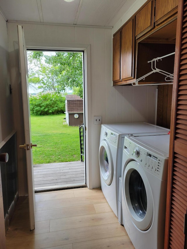 3211 S Partridge Point Rd, Alpena, MI 49707 - washroom with cabinet space, independent washer and dryer, and light wood-style flooring
