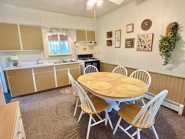 7770 Klein Rd, Hillman, MI 49746 - carpeted dining area with a ceiling fan, a wainscoted wall, wood walls, and a baseboard heating unit