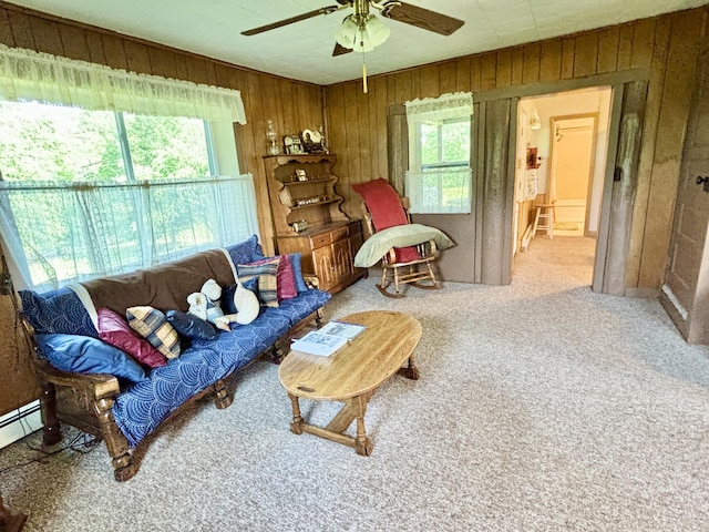 7770 Klein Rd, Hillman, MI 49746 - living area featuring wood walls, ceiling fan, plenty of natural light, and carpet flooring