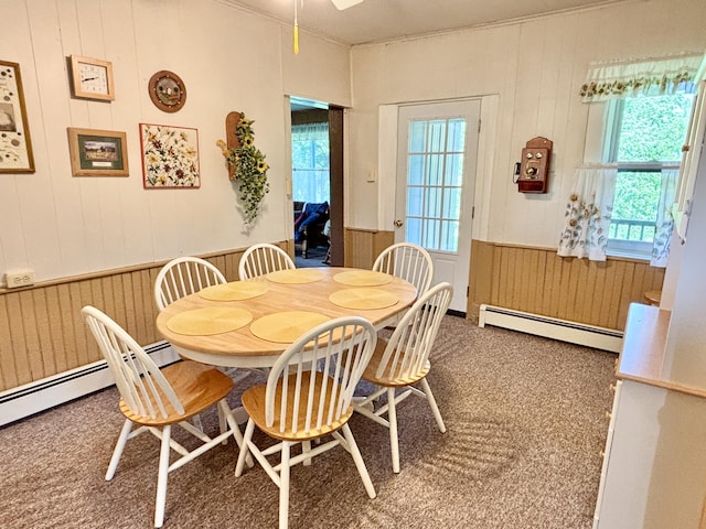 7770 Klein Rd, Hillman, MI 49746 - dining room featuring a baseboard heating unit, wood walls, a wainscoted wall, crown molding, and a ceiling fan