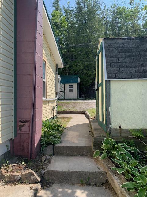 9319 Blue Horizon Rd, Presque Isle, MI 49777 - exterior space featuring a storage unit and a shingled roof