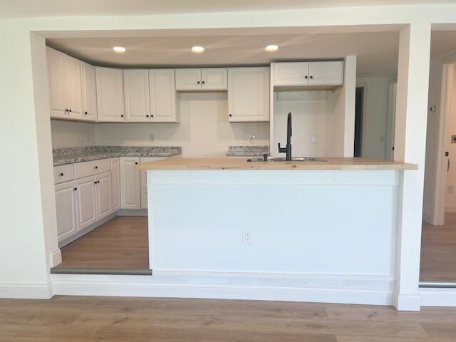 9319 Blue Horizon Rd, Presque Isle, MI 49777 - kitchen with white cabinets, light wood finished floors, recessed lighting, and light countertops