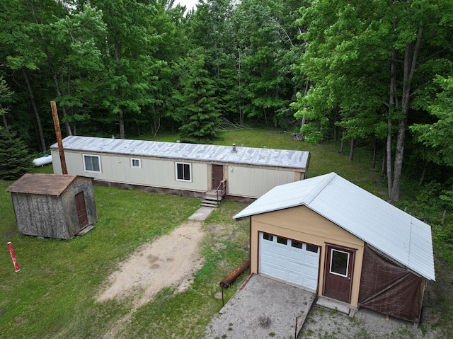 3178 Tobias Rd, Elmira, MI 49730 - view of front of home with a front yard, a garage, a view of trees, driveway, and a storage shed