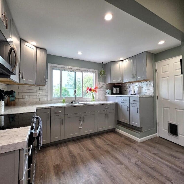 510 W Baldwin St, Alpena, MI 49707 - kitchen with appliances with stainless steel finishes, gray cabinetry, decorative backsplash, dark wood-style floors, and light countertops