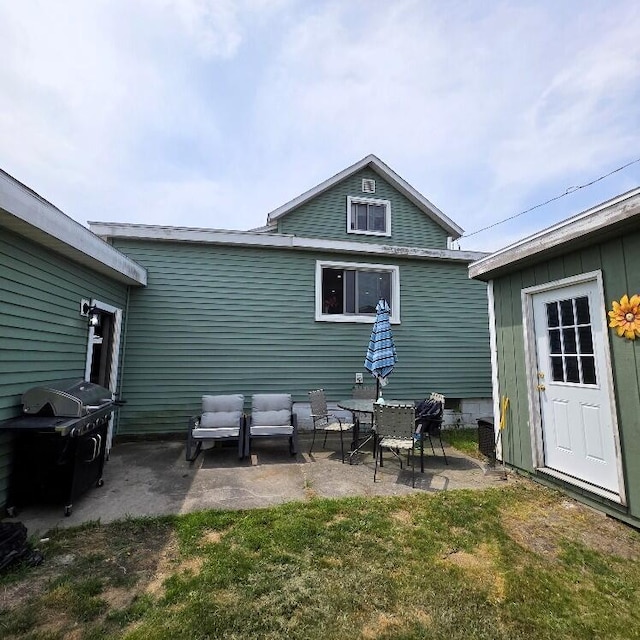 510 W Baldwin St, Alpena, MI 49707 - back of house featuring a patio, an outdoor living space, and a lawn