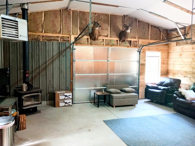 5228 S Brown Rd, Cadillac, MI 49601 - garage featuring a heating unit, wooden walls, and a wood stove