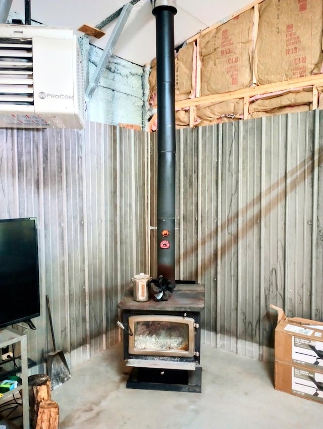 5228 S Brown Rd, Cadillac, MI 49601 - basement featuring a wood stove, wooden walls, and a heating unit