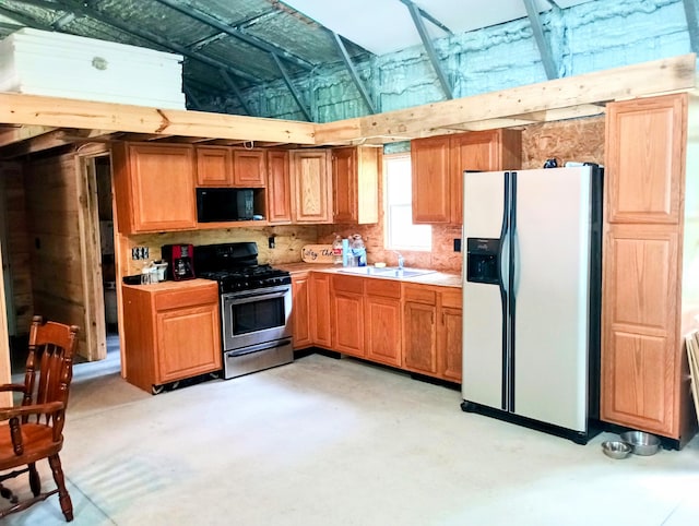 5228 S Brown Rd, Cadillac, MI 49601 - kitchen with stainless steel gas stove, fridge with ice dispenser, black microwave, concrete floors, and light countertops