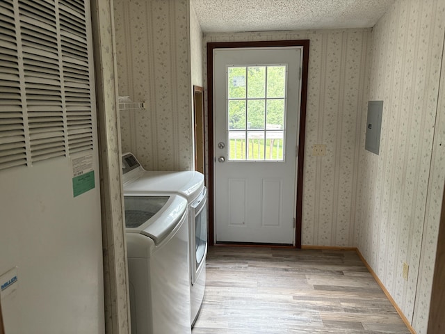 348 Lake Winyah Rd, Alpena, MI 49707 - washroom with a heating unit, independent washer and dryer, wallpapered walls, light wood-style flooring, and a textured ceiling