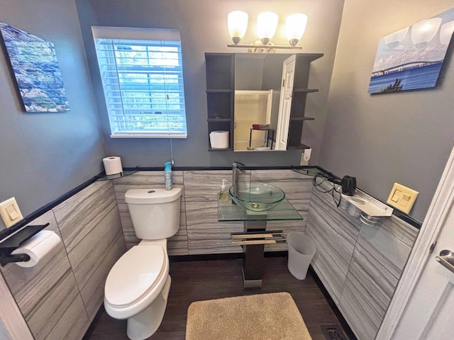 5514 N Bay Ct, Presque Isle, MI 49777 - half bathroom featuring tile walls, wainscoting, wood finished floors, and a chandelier