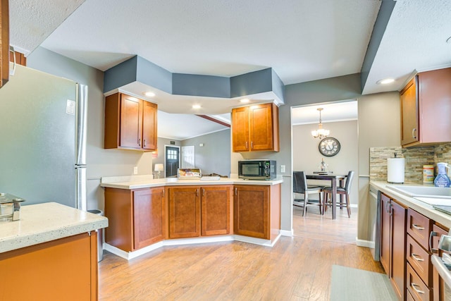 5514 N Bay Ct, Presque Isle, MI 49777 - kitchen with black microwave, freestanding refrigerator, light wood-style flooring, backsplash, and recessed lighting