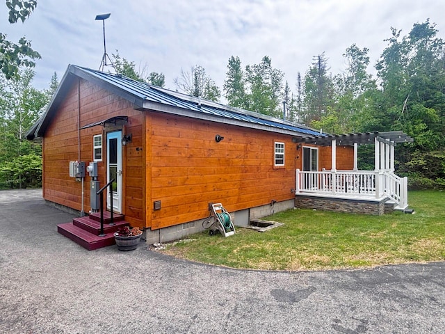 5514 N Bay Ct, Presque Isle, MI 49777 - view of home's exterior with a metal roof, a pergola, crawl space, and a yard