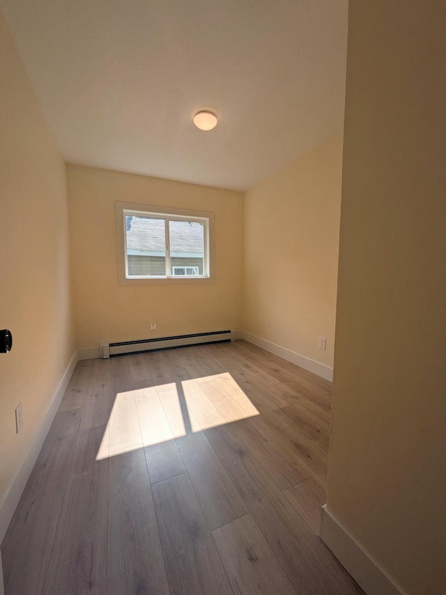 114 Pine St, Prudenville, MI 48651 - spare room with baseboard heating and wood finished floors
