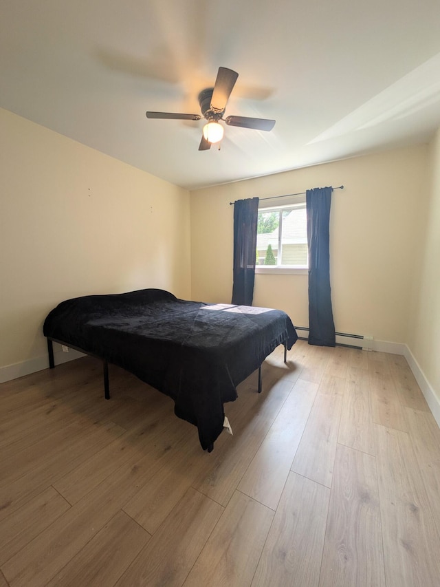 114 Pine St, Prudenville, MI 48651 - bedroom featuring light wood-type flooring, a ceiling fan, and baseboard heating