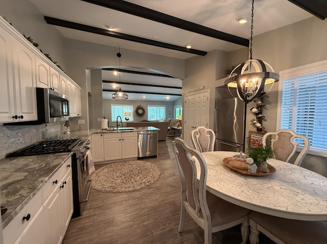 108 Bourbon St, Roscommon, MI 48653 - dining area featuring a chandelier, beamed ceiling, and dark wood finished floors